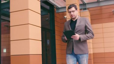 iş adamı gider bir toplantı ve iş üstünde belgili tanımlık gitmek tablet PC'de. bir adam akıllı bir saatine bakar. Elinde akıllı izlemek ve tablet bilgisayar.