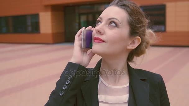 Piękna dziewczyna rozmawia przez telefon komórkowy. Aparat porusza się z modelem. zwolnionym tempie — Wideo stockowe