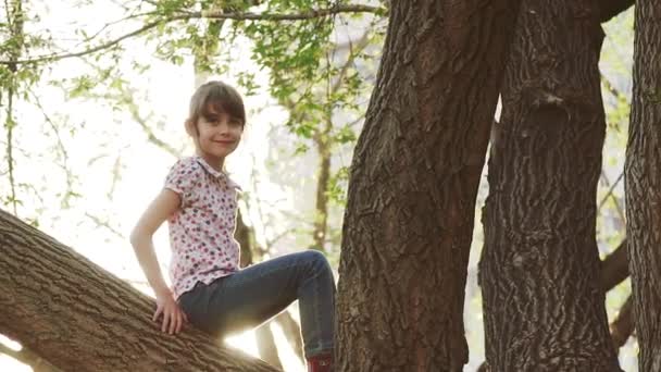 Kind klettert auf Baum. kleines Mädchen spielt im Freien. Zeitlupe — Stockvideo