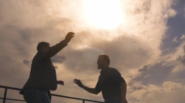 iki işadamları bir başarı kutluyor silüeti. adam bir meslektaşım için bir beşlik ver. ağır çekim