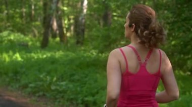 genç kadın yaz ormanda koşu. Kız spor doğada gider. sporcular geri. ağır çekim