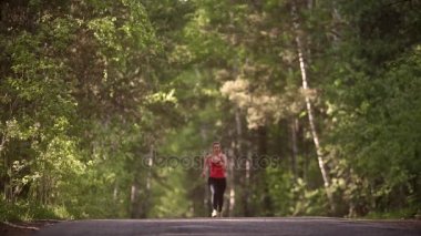 genç kadın koşu ve başarı sevinir. tat atlet zaferi ve sevinç. çekici kız spor yaz ormandaki devreye girer. ağır çekim