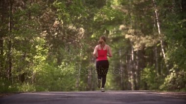 genç kadın koşu ve başarı sevinir. tat atlet zaferi ve sevinç. çekici kız spor yaz ormandaki devreye girer. ağır çekim