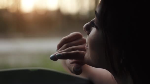 Hermosa chica mira por la ventana del coche y coge un viento de mano — Vídeos de Stock