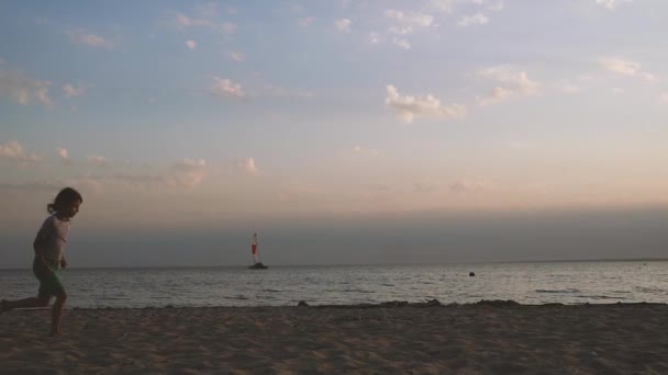小女孩在日落时分在沙滩上运行. — 图库视频影像