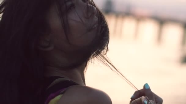 Hermosa chica en vestido ligero caminando en la playa al atardecer y sonriendo — Vídeos de Stock