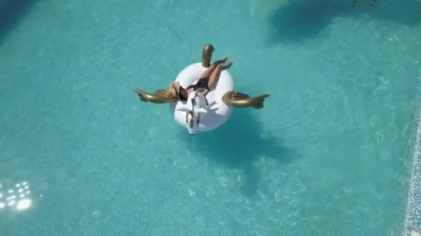 Aérea: joven mujer sexy en bikini flotando en un colchón de aire en la piscina. chicas atractivas tomando el sol. Tiro con quadrocopter — Vídeo de stock