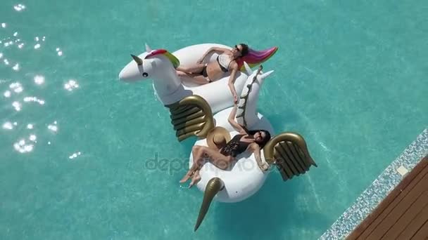 Aériennes - meilleures copines en vacances par une chaude journée ensoleillée. Filles sexy en maillots de bain bronzer et se détendre couché sur des matelas gonflables dans la piscine. Prise de vue avec quadrocopter — Video