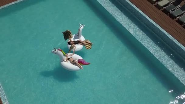 Antenne - Freundinnen sonnen sich an einem heißen Sommertag. sexy Mädchen im Bikini entspannen auf aufblasbarer Matratze im Pool. Schießen mit Quadrocopter — Stockvideo