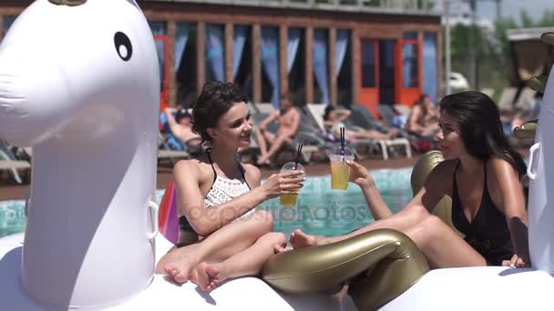 Καυτή θερινή ημέρα. σέξι κορίτσια με μπικίνι Χαλαρώστε και πίνουν κοκτέιλ δίπλα στην πισίνα. αργή κίνηση — Αρχείο Βίντεο