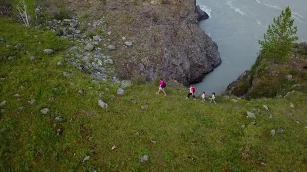Antenn. Lycklig familj i en vandring. föräldrar med småbarn promenera längs en bergsstig vid floden. Altai, Sibirien. Flygande kameran skott — Stockvideo