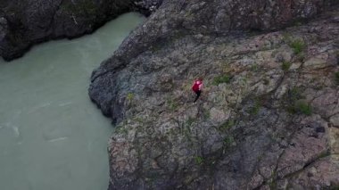 Hava. dağlarda uçurum boyunca kız seyahat sırt çantası ile yürür. kadın turist yürüyüşe. Altay, Sibirya. Hava kamera vurdu
