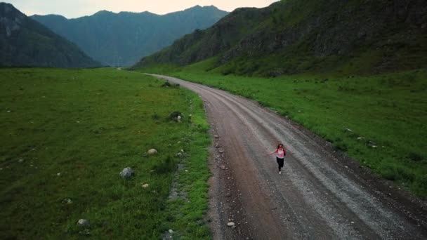 Εναέρια. σπορ κορίτσι ταξιδιώτης τρέχει προς την περιπέτεια. ταξιδεύει γυναίκα τουρίστας με το σακίδιο. Αλτάι, Σιβηρία. Εναέρια shot φωτογραφική μηχανή — Αρχείο Βίντεο