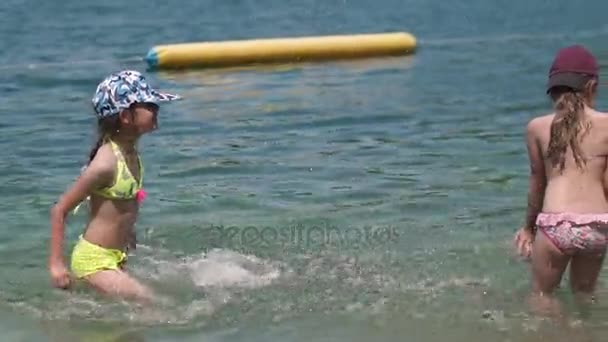 Niños nadan en el río y salpicando agua. Dos niñas disfrutan del descanso junto al agua. Niños divirtiéndose en el agua al aire libre. Movimiento lento — Vídeo de stock