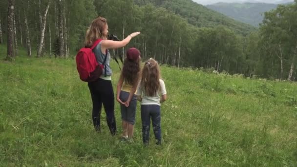 Familia de turistas viajan. mamá muestra la vista de hijas. niños mirando a través de prismáticos — Vídeo de stock
