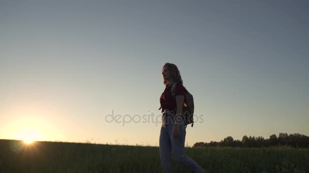 Kız turistik bir çayırda yürüyen bir sırt çantası ile — Stok video