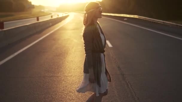 Menina despreocupada hipster caminha ao longo da estrada. câmara lenta — Vídeo de Stock