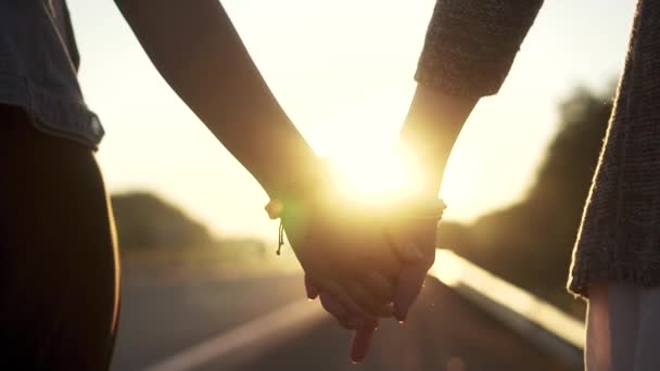 Novias mano al atardecer, primer plano. las chicas se toman de la mano y caminan por el camino. cámara lenta — Vídeo de stock