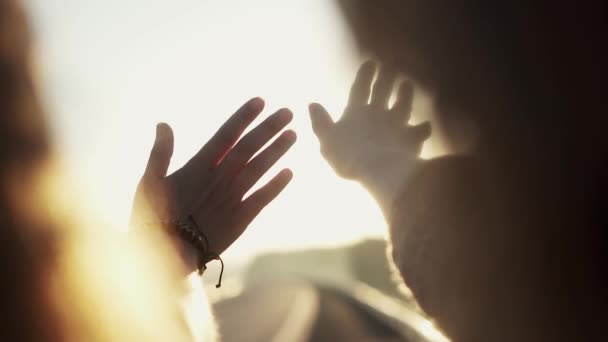 Девушки смотрят на восходящее солнце своими руками — стоковое видео