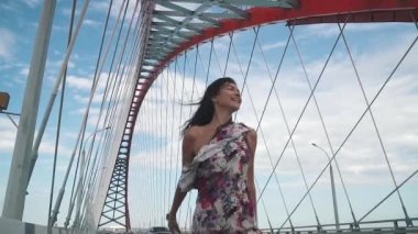 şehrin binalar arasında yürürken güzel bir genç kız portresi. kot pantolon ve tişört yaz şehirde yürüyüş bir genç kadın. ağır çekim