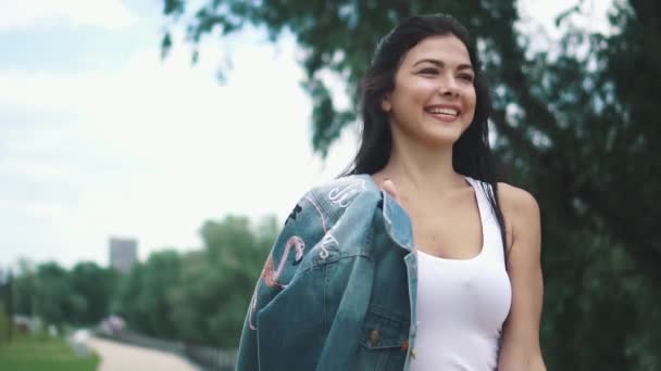 Красива дівчина в сорочці, що виходить на вулицю і насолоджується теплим літнім днем. повільний рух — стокове відео