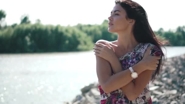 Чувственный крупным планом портрет красивой девушки в летнем платье на реке. замедленное движение — стоковое видео