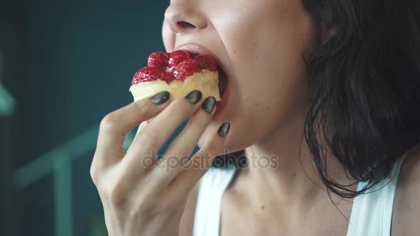 La belle fille mange un gâteau appétissant et boit du café. Lèvres femelles gros plan — Video