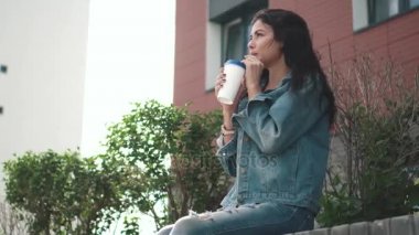 genç güzel kız sokakta bir kağıt bardak kahve içme denim ceket