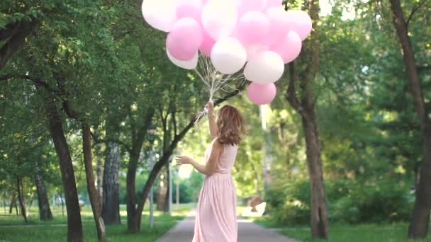 Mujer atractiva joven sosteniendo una gran cantidad de globos en las manos. Movimiento lento — Vídeos de Stock