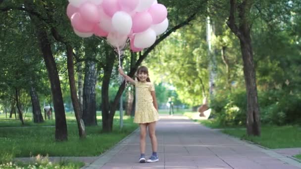 Портрет забавной маленькой девочки с воздушными шарами — стоковое видео