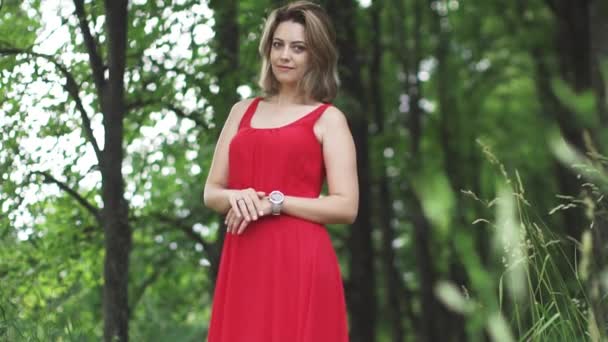 Portrait d'une jeune femme séduisante sur un fond bokeh arbre vert. au ralenti — Video