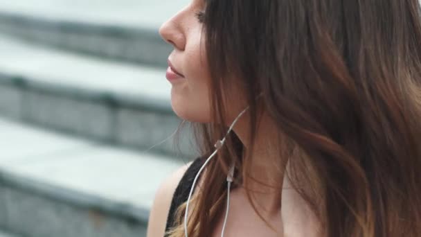 Портрет крупным планом девушки, слушающей музыку в наушниках — стоковое видео