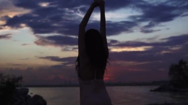 siluet seashore batımında dans eden kız. ağır çekim