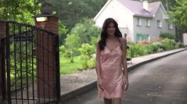 Akşam elbiseli bir kız portresi. Genç bir kadın, dikkatsizce cadde boyunca yürür