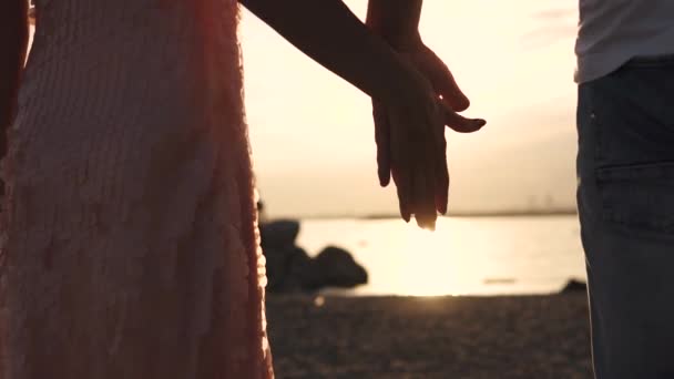 Um toque de mãos masculinas e femininas contra o pôr do sol. Amor, romance, relacionamentos — Vídeo de Stock