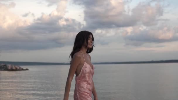 Chica en vestido de cóctel paseos despreocupados en la playa al atardecer — Vídeo de stock