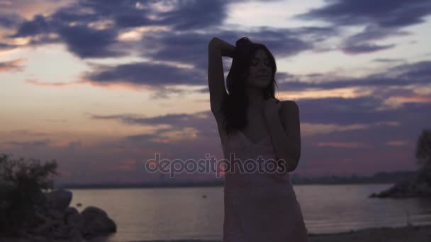 Ragazza in abito da sera che danza sessualmente su sfondo tramonto. silhouette di una ragazza danzante su uno sfondo tramonto. bella ragazza ballare e divertirsi all'aperto — Video Stock