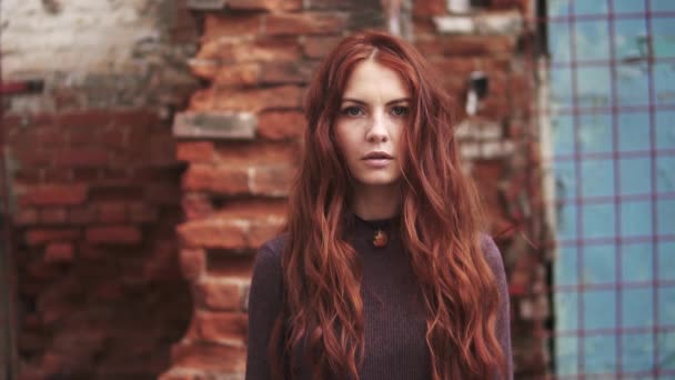 Primo piano ritratto di una ragazza dai capelli rossi con uno sguardo misterioso. ragazza con lentiggini guarda la fotocamera — Video Stock