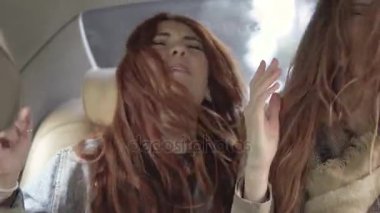 Arabanın arka koltuğunda oturan dans deli kızlar. Kız birlikte eğlenin. 20'li