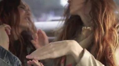 Arabanın arka koltuğunda oturan dans deli kızlar. Kız birlikte eğlenin. 20'li