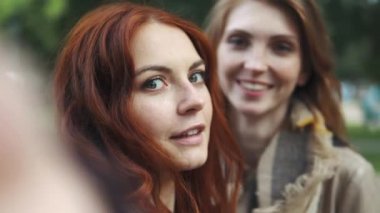 Bir akıllı telefon ile selfie alarak ve yüzleri ve eğlenceli hale Kızıl saçlı arkadaşlar. 20'li
