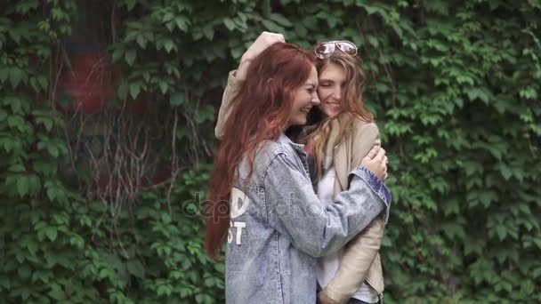 Девушки смеются и обнимаются. Две красивые рыжие девушки улыбаются и позируют перед камерой. 20-е годы — стоковое видео