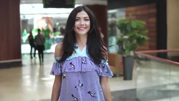 Retrato de cerca de una chica con bolsas de compras en un centro comercial — Vídeo de stock