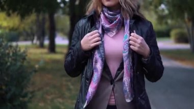 Genç kadın soğutulmuş ve kendini bir eşarp sarılmış. sonbahar parkta donmuş kız