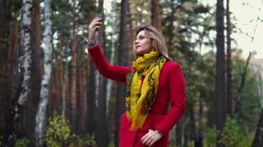 genç kadın kırmızı paltolu bir sonbahar park boyunca yürüyüş. güzel kız sıcak bir sonbahar öğleden sonra zevk