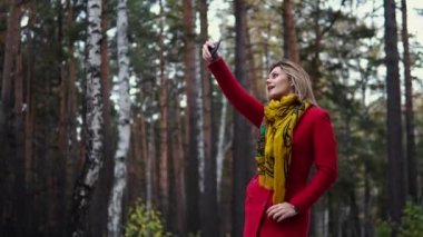 genç kadın kırmızı paltolu bir sonbahar park boyunca yürüyüş. güzel kız sıcak bir sonbahar öğleden sonra zevk