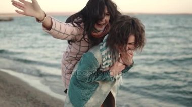 iki genç çekici kızlar eğlenceli ve kucaklama var. arkadaşlarım birlikte açık havada deniz kenarında vakit. gün batımında sahilde kız portresi