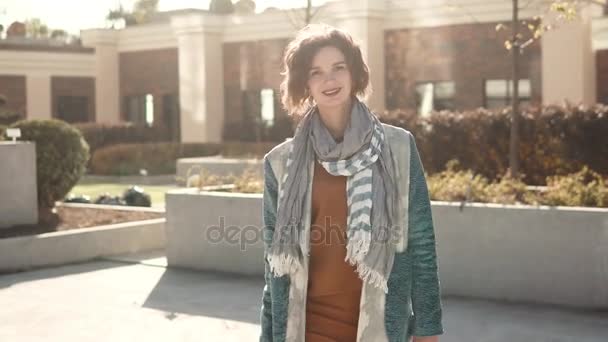 Närbild porträtt av en fashionabel ung kvinna i solens strålar. vacker flicka på en stad bakgrund — Stockvideo