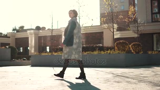 Mujer joven caminando en la ciudad de otoño al atardecer . — Vídeo de stock
