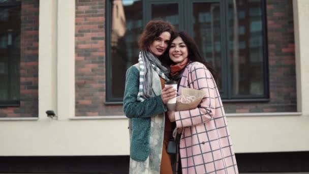 Portrait of two girlfriends against a background of modern architecture. girlfriends embrace — Stock Video